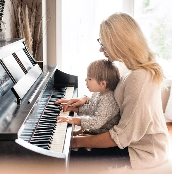 IN CRAFT AND ENTAINMENT,THE THE EASIEST WAY TO LEARN THE PIANO. PHOTO OF MOTHER AND CHILD AT PIANO