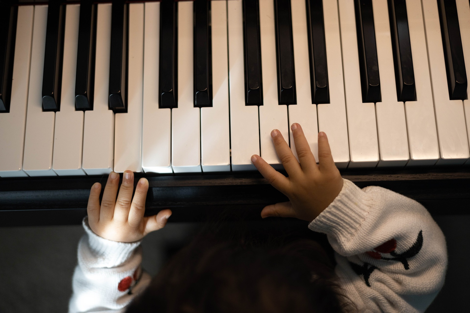 ARTS &  ENTERTAINMENT A child sitting with hands on the piano